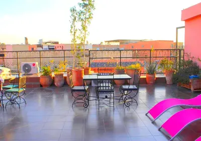 a patio with a table and chairs and plants at Miramare Marrakech in Marrakech
