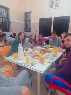 a group of people sitting around a table eating food at Miramare Marrakech in Marrakech