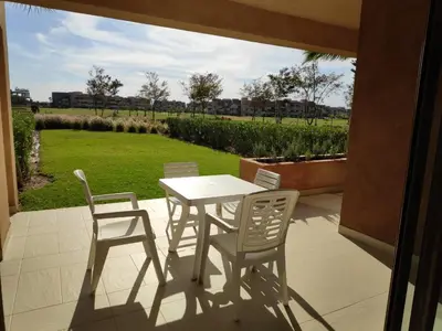 a white table and chairs on a patio at Magnifique appart vue sur golf in Marrakech
