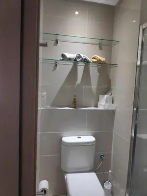 a bathroom with a toilet and a glass shelf at Magnifique appart vue sur golf in Marrakech
