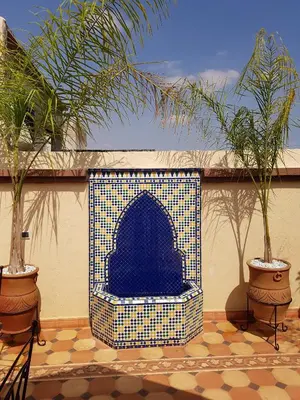 a fireplace in a patio with two potted plants at Riad Espressino exclusive Marrakech in Marrakech