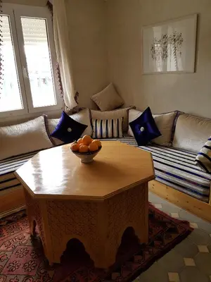 a living room with a table and a couch at Riad Espressino exclusive Marrakech in Marrakech