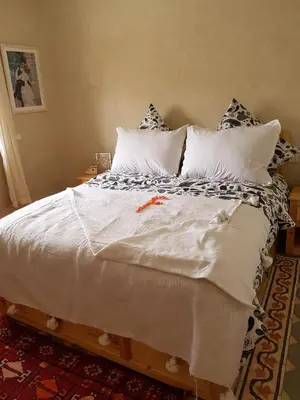 a large bed with white sheets and pillows at Riad Espressino exclusive Marrakech in Marrakech