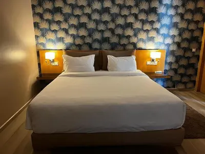 a bedroom with a large white bed with two lamps at Palms Edge Villas avec Piscine & Jardin Privés in Marrakech