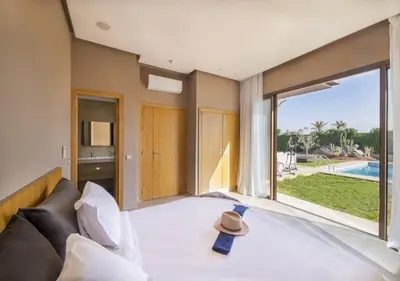 a bedroom with a large bed and a large window at Palms Edge Villas avec Piscine & Jardin Privés in Marrakech