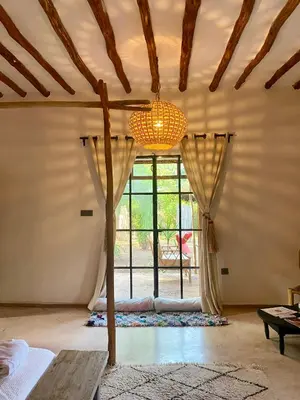 a room with a large window and a chandelier at La Ferme Berbere in Marrakech