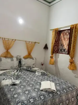 a bedroom with a bed and a window with curtains at Riad Mahjouba Marrakech & SPA in Marrakech