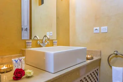 a bathroom with a white sink and a red rose at Riad Azoulay in Marrakech
