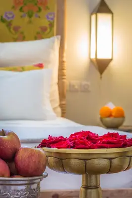 a tray of roses and apples on a table in a hotel room at Riad Azoulay in Marrakech