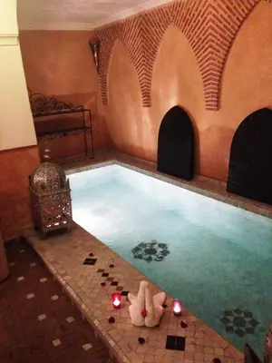 a swimming pool with candles in a room at Riad Bjoujna in Marrakech