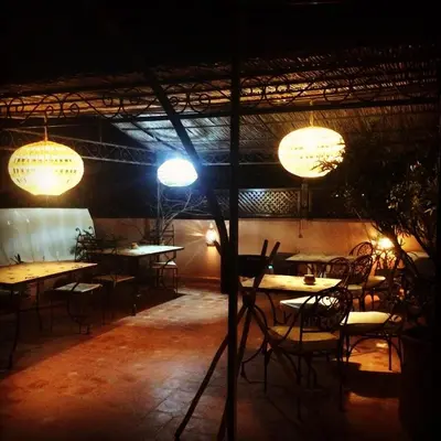 a restaurant with tables and chairs and lights at Riad Bjoujna in Marrakech