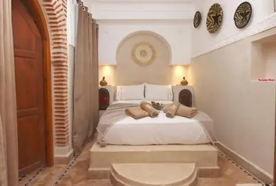 a bedroom with a white bed with two teddy bears on it at Riad Venezia in Marrakech