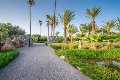 a path through a garden with palm trees at Zagora and Marhba villas Marrakech - by EMERALD STAY in Marrakech