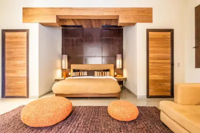 a bedroom with a bed and two ottomans at Zagora and Marhba villas Marrakech - by EMERALD STAY in Marrakech