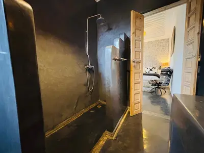 a bathroom with a shower stall and a door at Riad Instant T in Marrakech
