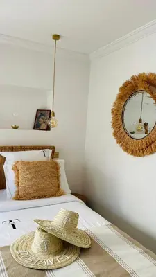 a hat on a bed with a mirror on the wall at Riad Instant T in Marrakech