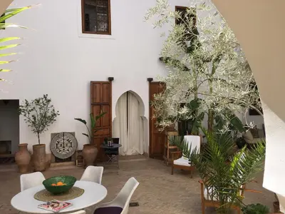 a room with a table and chairs and plants at Riad UP in Marrakech