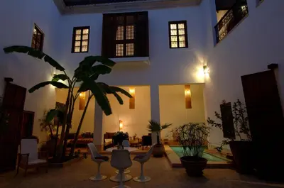 a large living room with chairs and a plant at Riad UP in Marrakech