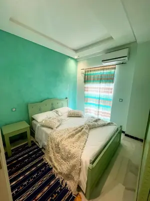 a bedroom with a bed and a window and a rug at Stylish Moroccan Apartment Gueliz City Centre in Marrakech