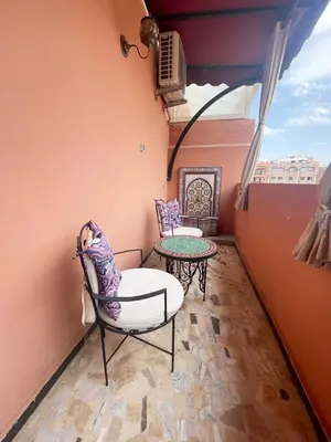 a balcony with a chair and a table at Stylish Moroccan Apartment Gueliz City Centre in Marrakech