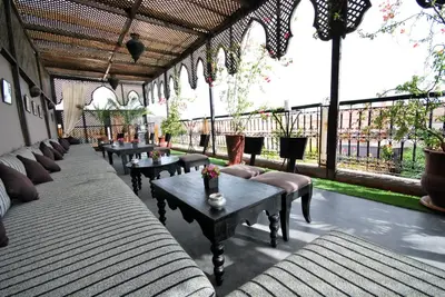 a patio with couches and tables and windows at Riad Terra Bahia in Marrakech