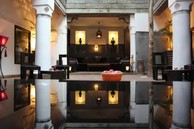 a lobby with a reflection in a pool of water at Riad Terra Bahia in Marrakech