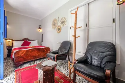 a bedroom with a bed and two chairs at Riad Bobby Marrakech in Marrakech