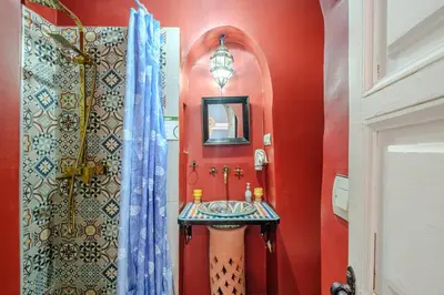 a bathroom with a sink and a red wall at Riad Bobby Marrakech in Marrakech