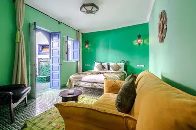 a green bedroom with a bed and a couch at Riad Bobby Marrakech in Marrakech