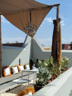 a rooftop patio with tables and potted plants at DAR AURORA in Marrakech