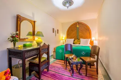 a hotel room with a bed and a desk and a desk at Riad Sable Chaud in Marrakech