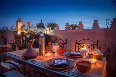 a table with plates of food and wine glasses at Riad Sable Chaud in Marrakech