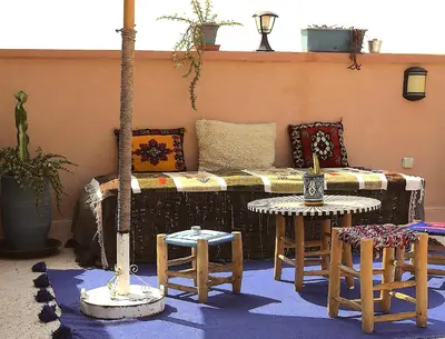 a patio with a couch and two tables and chairs at Riad Ambre et Jasmin in Marrakech