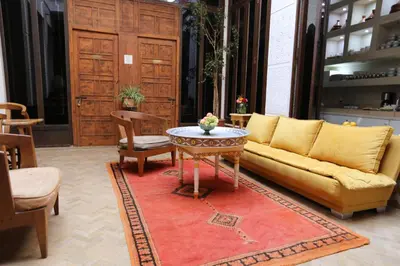 a living room with a yellow couch and a table at Riad Ambre et Jasmin in Marrakech