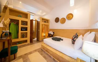 a bedroom with a white bed and some shelves at Riad Ambre et Jasmin in Marrakech