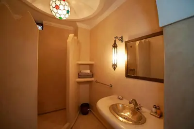 a bathroom with a sink and a mirror at Riad des trois palais in Marrakech