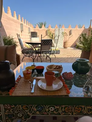 a table with a tray of food on a patio at Riad des trois palais in Marrakech
