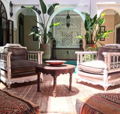 a living room with chairs and a table with a bowl on it at Riad Palacio De Las Especias in Marrakech