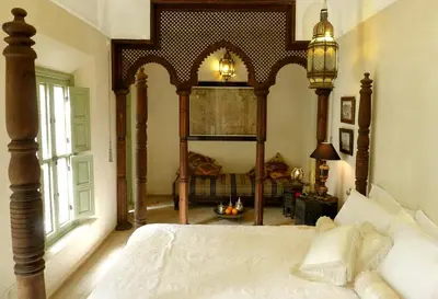 a bedroom with a large bed with a wooden canopy at Riad Palacio De Las Especias in Marrakech