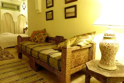 a living room with a couch and a lamp on a table at Riad Palacio De Las Especias in Marrakech