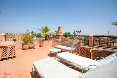 a balcony with beds and a view of the city at Riad Marélia in Marrakech