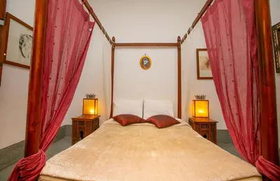 a bedroom with a canopy bed with red curtains at Riad Marélia in Marrakech
