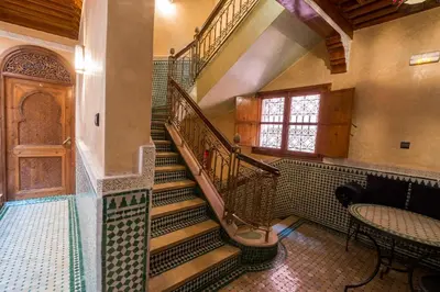 a spiral staircase in a building with a table and a window at Riad Saad in Marrakech