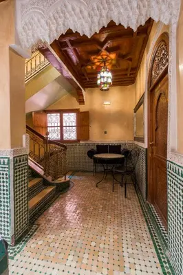 an empty room with a table and stairs in a building at Riad Saad in Marrakech