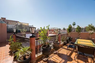 a balcony with plants and a table and chairs at Ryad Hamza in Marrakech