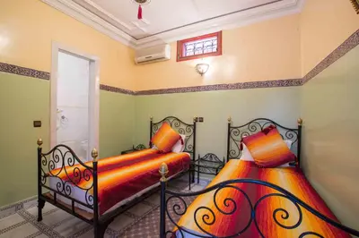 a bedroom with two beds and a window at Ryad Hamza in Marrakech