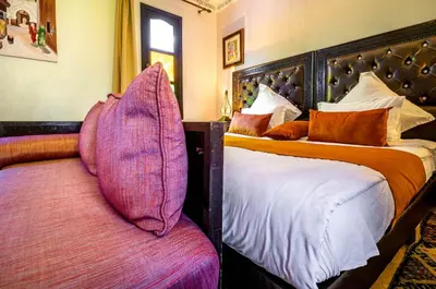 a bedroom with two beds with purple pillows at Kasbah Alili in Marrakech