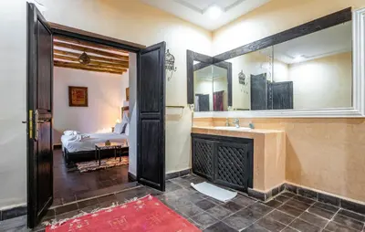 a bathroom with a fireplace and a bedroom with a bed at Kasbah Alili in Marrakech