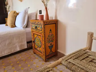 a wooden cabinet with vases on it next to a bed at Riad Casa Sophia in Marrakech