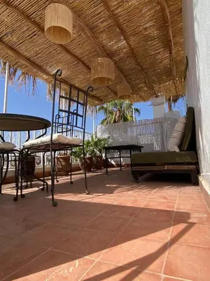 a patio with tables and chairs under a roof at Riad Casa Sophia in Marrakech